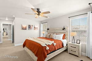 Bedroom featuring light carpet, visible vents, a ceiling fan, and baseboards