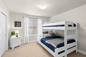 Bedroom featuring visible vents, baseboards, light colored carpet, and a textured ceiling