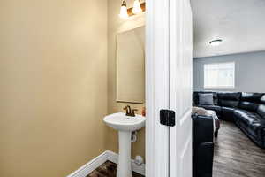 Bathroom with baseboards and wood finished floors