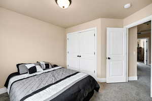 Bedroom featuring baseboards, a closet, and carpet