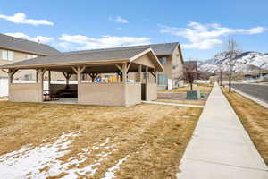 Exterior space with roof with shingles, stucco siding, a mountain view, and a patio