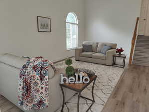 Living room with wood finished floors, stairs, and baseboards
