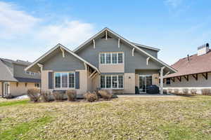 Rear view of property with a lawn, stucco siding, and a patio area