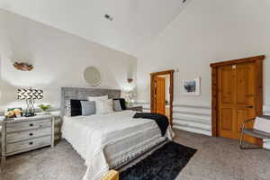 Bedroom featuring visible vents, high vaulted ceiling, and carpet flooring