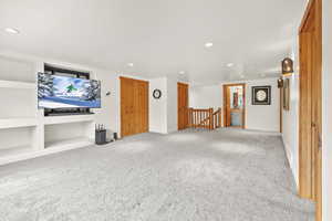Unfurnished living room with baseboards, recessed lighting, and carpet