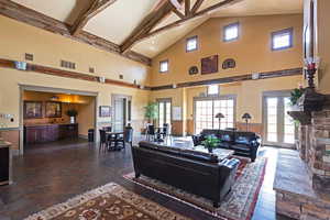 Living area with a healthy amount of sunlight, beamed ceiling, and visible vents
