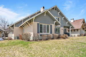 Exterior space with a chimney, stucco siding, and a yard