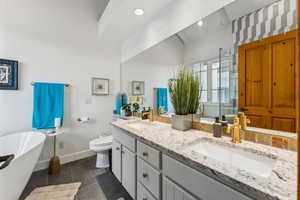 Full bathroom with tile patterned flooring, a sink, toilet, and double vanity