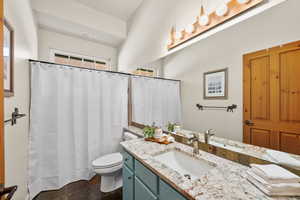 Full bath with toilet, vanity, and a shower with shower curtain