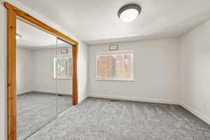 Unfurnished bedroom with baseboards, visible vents, a closet, and carpet