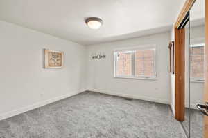 Unfurnished bedroom with baseboards, visible vents, and carpet