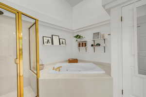 Full bathroom featuring a jetted tub and a shower stall