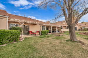 Rear view of house with stucco siding, a yard, a patio, and a pergola