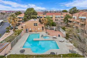 Pool featuring fence, a residential view, a patio area, and a hot tub