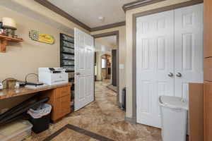 Bathroom with stone finish floor, baseboards, and ornamental molding