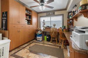 Home office featuring ceiling fan and ornamental molding