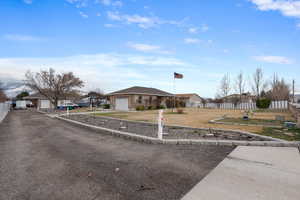 View of front of property featuring a residential view, fence, a garage, and concrete driveway