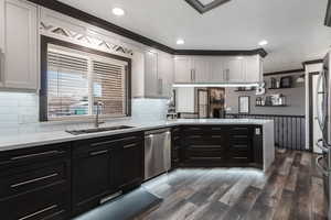 Kitchen featuring light countertops, a sink, a peninsula, stainless steel appliances, and white cabinets