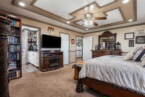 Carpeted bedroom with a tray ceiling, connected bathroom, ornamental molding, and recessed lighting