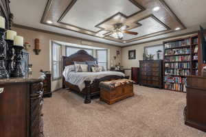 Bedroom with a tray ceiling, light colored carpet, crown molding, and recessed lighting