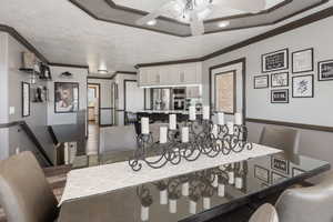Dining area featuring a ceiling fan, wood finished floors, and crown molding