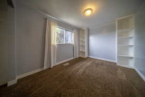 Carpeted empty room featuring baseboards, a textured ceiling, and visible vents