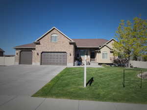 Ranch-style house featuring fence, roof with shingles, concrete driveway, brick siding, and a front yard