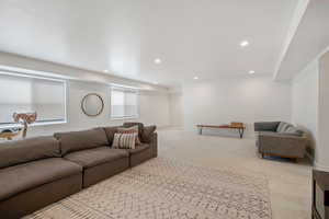 Living area featuring recessed lighting, baseboards, and light colored carpet