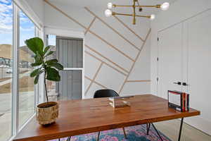Carpeted home office with a chandelier