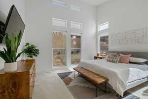 Bedroom with visible vents, baseboards, a towering ceiling, and carpet flooring