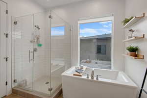 Bathroom featuring a shower stall and a bath