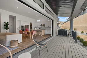 Deck with area for grilling, exterior kitchen, visible vents, and a sink