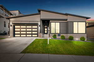 Contemporary house with a garage, a front yard, and driveway