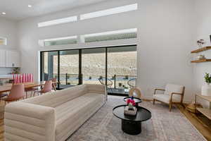 Living area featuring a high ceiling, recessed lighting, wood finished floors, and baseboards