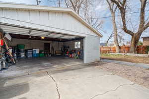 Garage featuring fence and a garage door opener