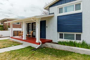 Doorway to property featuring covered porch and fence