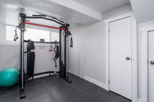 Exercise room with baseboards and a textured ceiling
