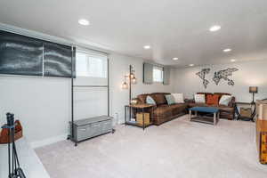 Family room with baseboards, a textured ceiling, recessed lighting, and light carpet