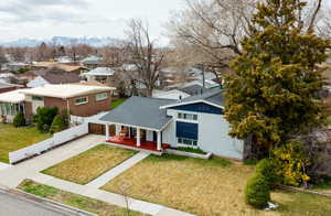 View of front of home featuring a residential view, driveway, a mountain view, a front lawn, and brick siding
