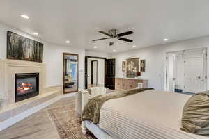 Bedroom with light wood-style flooring, recessed lighting, and a tile fireplace