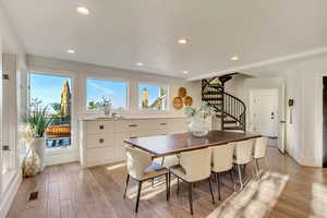 Dining room featuring a wealth of natural light, light wood-style flooring, and stairway