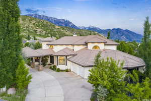 Mediterranean / spanish-style home featuring a tiled roof, stucco siding, a mountain view, and an attached garage
