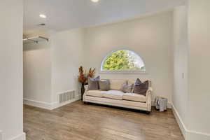 Sitting room featuring wood finished floors, baseboards, and visible vents