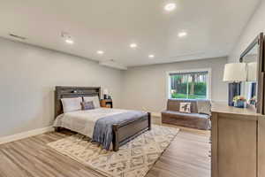 Bedroom with baseboards, visible vents, and light wood-style floors