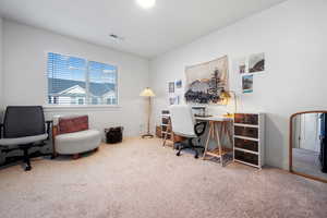 Office area featuring baseboards, visible vents, and carpet