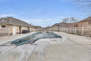 Pool with a fenced backyard and a patio
