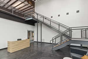 Interior space featuring baseboards, visible vents, a high ceiling, and finished concrete floors