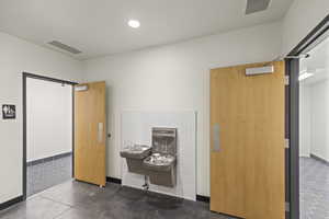Interior space featuring baseboards, visible vents, recessed lighting, and finished concrete floors