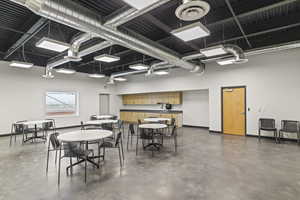Dining area with a high ceiling, concrete floors, and baseboards