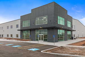 View of building exterior featuring uncovered parking